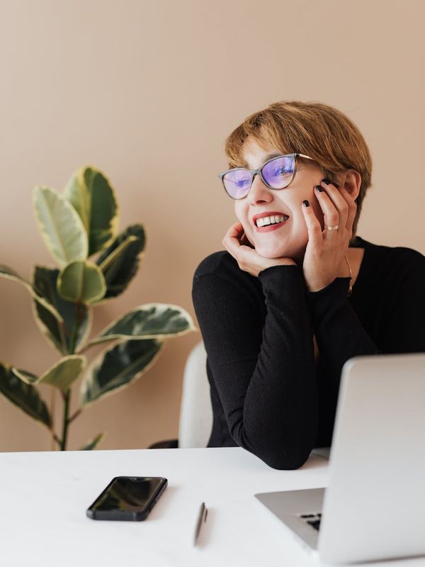 Office worker stretching gently at their desk with a smile.